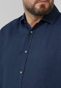 Navy blue lniana koszula z kołnierzykiem, zapięciem na guziki z przodu i jasnymi guzikami. Gładka tekstura i dopasowany krój.