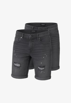 Grøn bomulds T-shirt med grafisk tekstdesign; parret med grå denimshorts med slidte detaljer; sorte sneakers.