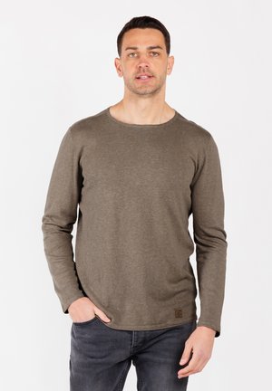 Langärmliger, olivgrüner Rundhalspullover aus weichem Stoff, mit einem kleinen Logopatch am Saum und einem lockeren Schnitt.