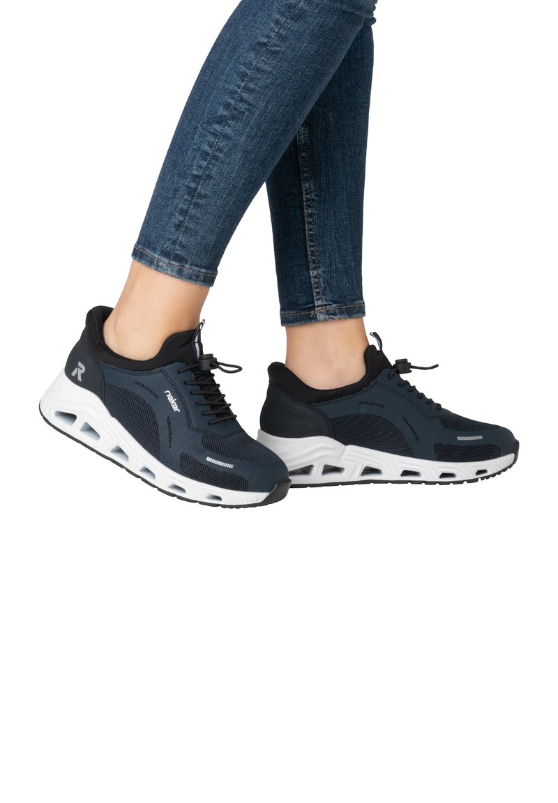 Svarta och marinblå mesh-sneakers med vit sula, med rundad tå, snörningsdesign och synliga dämpningssegment på sulan.