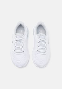Zapatillas deportivas blancas con parte superior de malla transpirable, cordones planos y suela texturizada. Sin logos o acentos visibles. Diseño simple y aerodinámico.