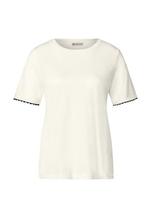 Vit kortärmad t-shirt i bomull med vågigt svart kant på ärmarna och rund hals. Slät textur, avslappnad passform.