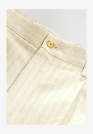 Heledad beežist lõngast valmistatud püksid õrna triibutusmustriga, millel on vööl ümmargune nelja auguga beež nööbi.