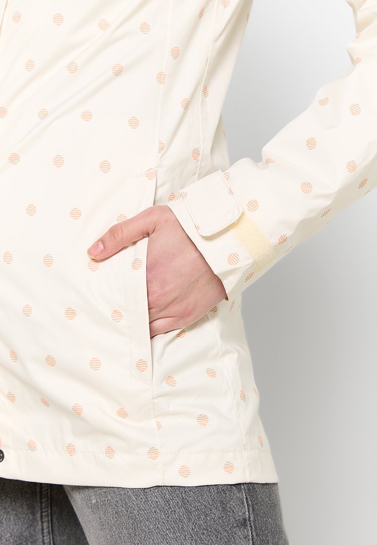 Lichtgekleurde jas met een gladde textuur, voorzien van een patroon van kleine, perzikgestreepte cirkels. Inclusief een zijzak en een knoopsluiting bij de manchetten.