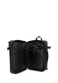 Mochila azul marino con dos compartimentos, que presenta un exterior liso, forro negro, un bolsillo frontal y dobles cremalleras para un acceso fácil.