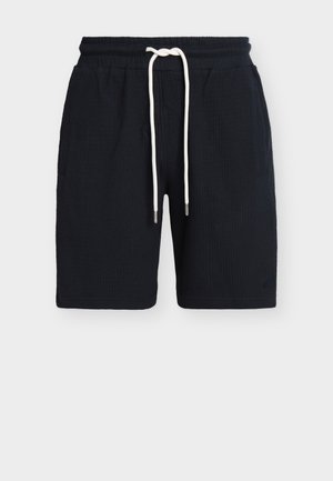 Sorte teksturerede shorts med elastisk talje og lange hvide snørebånd, med sidelommer og sømløse designdetaljer.