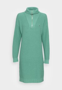 Robe pull en tricot vert menthe avec un col haut, fermeture éclair mi-haute et texture côtelée. Présente des manches larges et une coupe décontractée.