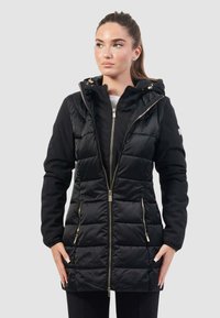 Giacca nera imbottita con zip frontale, cappuccio e tasche laterali. Presenta una texture trapuntata e dettagli metallici dorati.