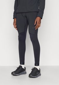 Colanți de sport negri cu un design ajustat, având panouri contrastante, cusături plate și un accent cu logo. Asortați cu încălțăminte sport neagră.