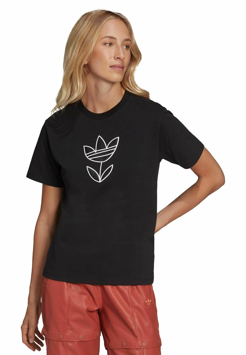 T-shirt in cotone nero con un logo floreale bianco al centro, maniche corte e scollatura rotonda. Design semplice e minimal.