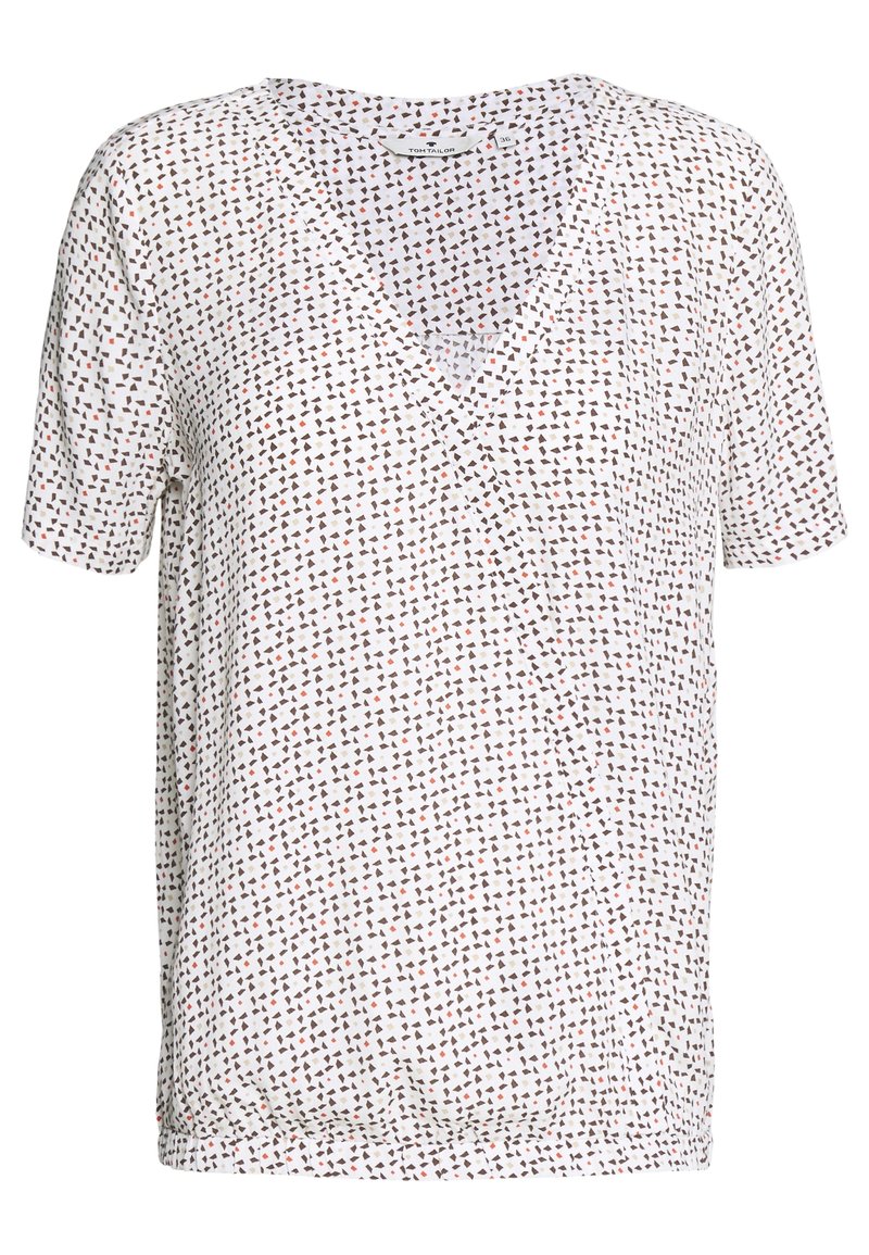 Weißes Kurzarmoberteil mit V-Ausschnitt und verstreutem geometrischem Muster in Braun, Schwarz und Rot. Weiches Baumwollgewebe mit legerer Passform.
