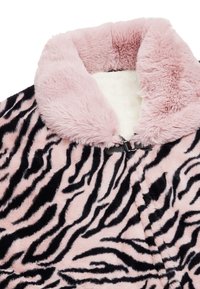 Cappotto in pelliccia sintetica rosa con motivo a strisce di tigre nere, dotato di un colletto morbido e peloso e di una chiusura argento al collo.