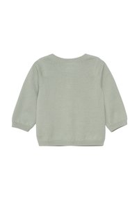 Ljust grön tröja med långa ärmar, ribbad halsringning och mudd, texturerad stickad mönster och rak fåll. Bakifrån visas.