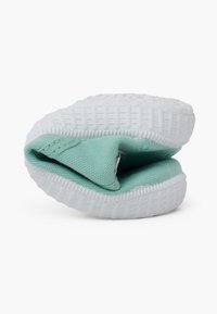 Scarpa slip-on verde in tessuto con superficie testurizzata, suola in gomma bianca e forma arrotondata, caratterizzata da un design ripiegato per un facile stoccaggio.