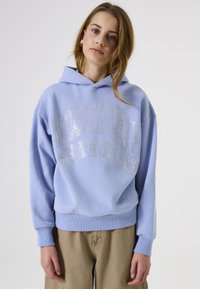 Sudadera azul claro de corte holgado, con "DOWNTOWN LOS ÁNGELES" en strass plateados en la parte frontal. Material de algodón suave, puños acanalados.