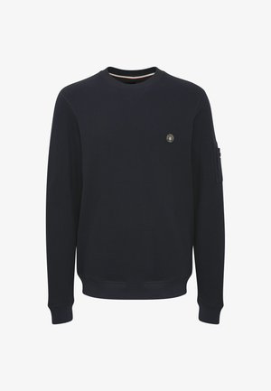 Temno modra majica s dolgimi rokavi, okroglo izrezana, teksturirana tkanina, majhen grb na prsih ter rebrasti manšeti in rob.