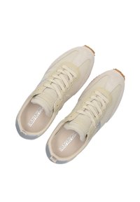 Beige Sneaker mit einer strukturierten Wildleder- und glatten Leder-Oberfläche, grauer Zehenkappe und heller Gummi-Sohle. Schnürdesign mit Branding auf der Zunge.