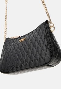Schwarze gesteppte Handtasche mit strukturierter Oberfläche, goldenen Hardware-Elementen und einer Kettenriemen. Verfügt über einen Reißverschluss und ein Markenlogo auf der Vorderseite.