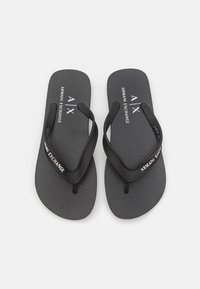 Černé žabky s texturovanou šedou podrážkou, s černým páskem a bílým logem "Armani Exchange". Lehký design pro volnočasové nošení.