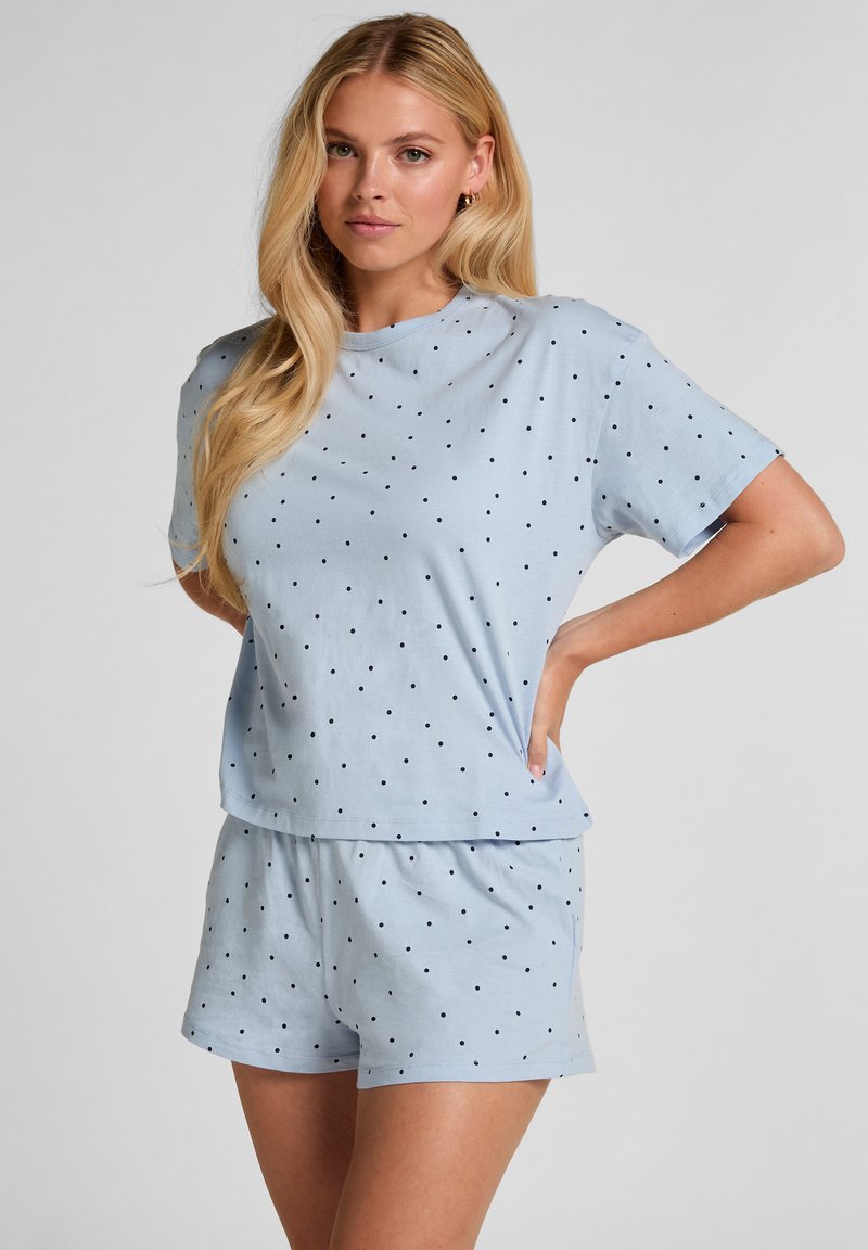 Lichtblauw setje met kort shirt en bijpassende korte broek, gemaakt van zachte stof met zwarte polka dots. Heeft een losse pasvorm en een elastische tailleband.