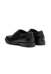 Pantofi de dress din piele neagră cu un finisaj neted, vârf rotunjit și toc jos, stratificat. Prezintă închidere cu șireturi și detalii fine de cusătură.