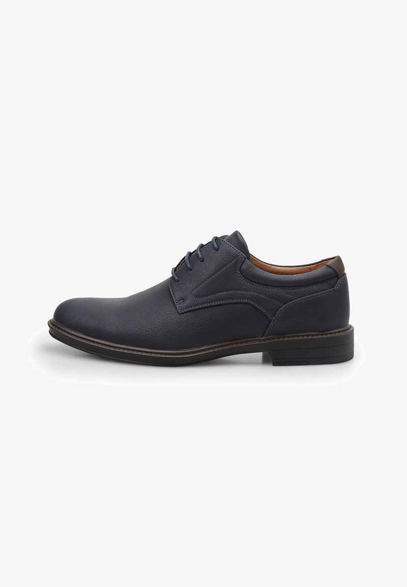 Zapato de vestir para hombre de cuero azul oscuro con cordones, detalle en marrón y tacón bajo, mostrado de perfil sobre fondo blanco.