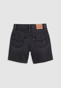 Short en jean noir avec deux poches arrière, un patch marron Levi's sur la ceinture et une étiquette rouge Levi's sur la poche droite.