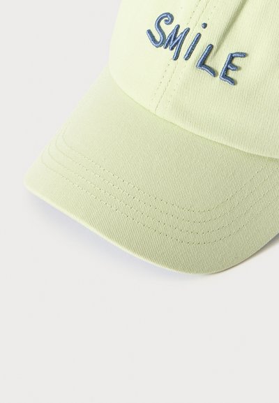 Casquette de baseball vert clair avec le mot brodé en bleu "SMILE" sur le panneau avant, montrant des coutures détaillées sur la visière.