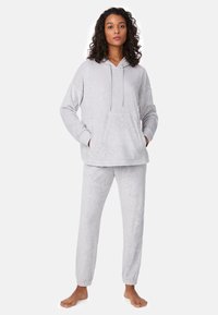 Conjunto de sudadera con capucha y pantalones jogger gris claro con un patrón abstracto sutil. La sudadera incluye un bolsillo canguro y cordón ajustable. Tela suave y pantalones con puños.