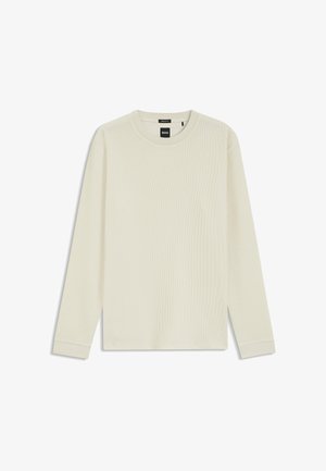 T-shirt à col rond en maille gaufrée couleur crème à manches longues avec poignets côtelés et étiquette de marque à l'intérieur du col.