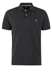 Polo noir en coton avec une patte de boutonnage à trois boutons, manches courtes, et un petit logo brodé sur le côté gauche de la poitrine.