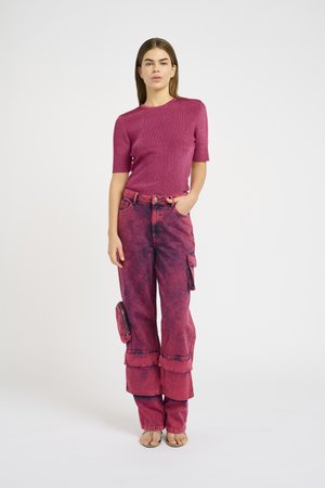Fittet magenta sweater med korte ærmer, parret med højtaljede, løstsiddende, lyserøde denim cargo bukser med lommer og flæse-detaljer.