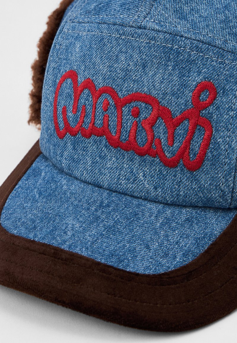 Blue denim cap with brown trim, featuring red embroidered "Mario" text on the front panel.