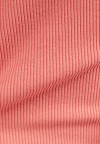 Ribbed fabric in a soft coral color, featuring fine vertical stripes and a smooth texture, showcasing folds and gentle waves.