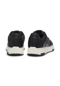 Svarte lær sneakers med teksturert design, hvit mellomsåle og svart gummisåle. Har polstret krage og hæl for komfort.