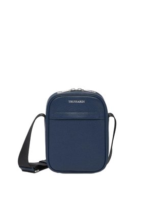 Sac bandoulière en cuir texturé bleu marine avec fermeture éclair, poche avant et sangle en tissu réglable. Présente un logo à l'avant.