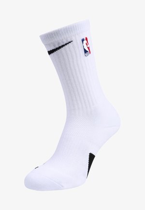 Chaussette de basket-ball blanche avec texture côtelée, logo Nike et logo NBA. Possède un rembourrage au niveau du pied et un accent noir près de la cheville.