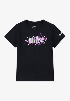 Musta puuvillainen t-paita, jossa on violetti painettu "Nike"-logo sydämillä ja tähdillä. Sisältää hopean värisen Nike-swooshin hihassa.