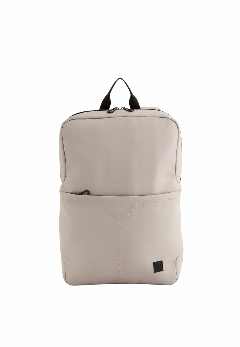 Ljusbeige ryggsäck gjord av mjukt material, med en framficka, svart dragkedja och handtag på toppen för enkel transport. Slät yta.