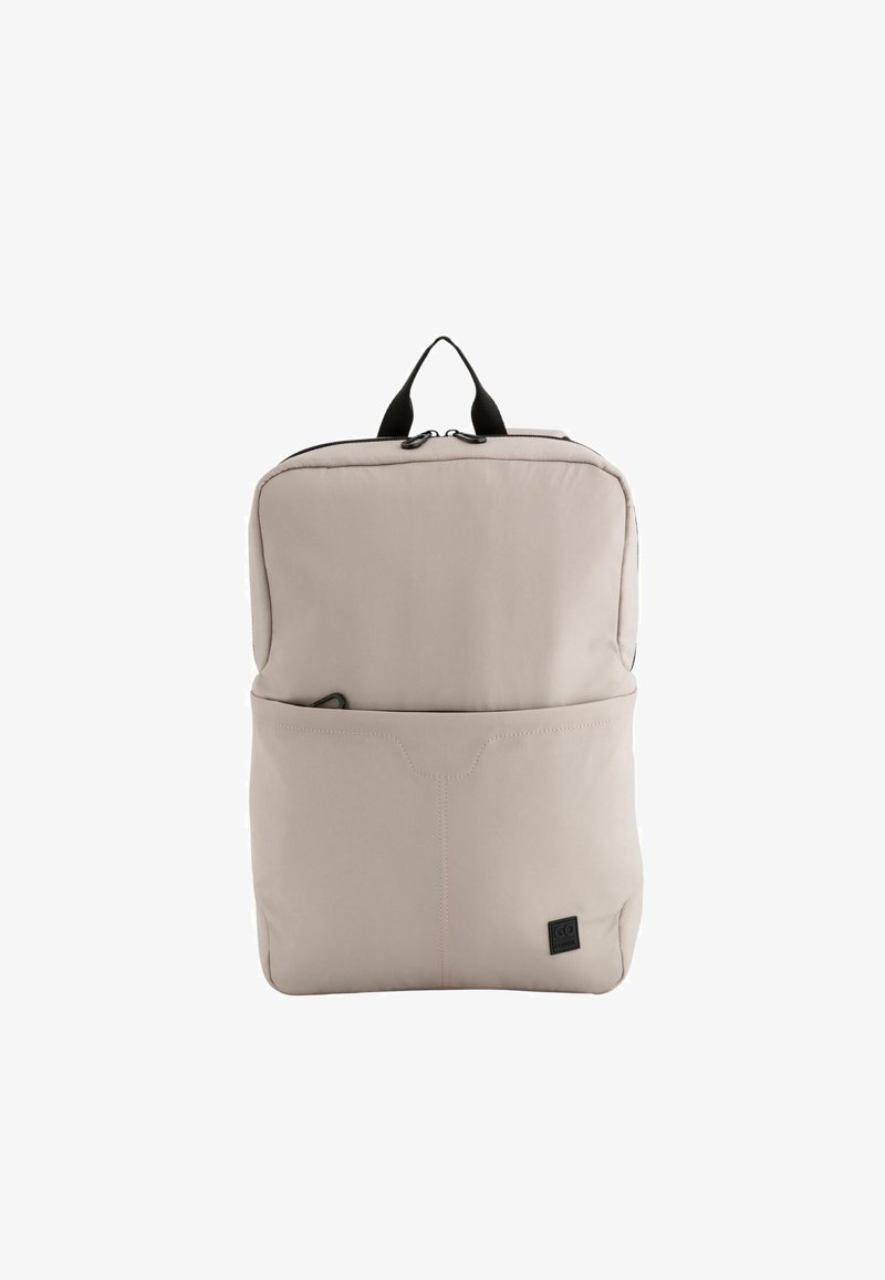 Lysbeige rygsæk lavet af blødt materiale, med en frontlomme, sort lynlås og top-håndtag for nem transport. Glat tekstur.