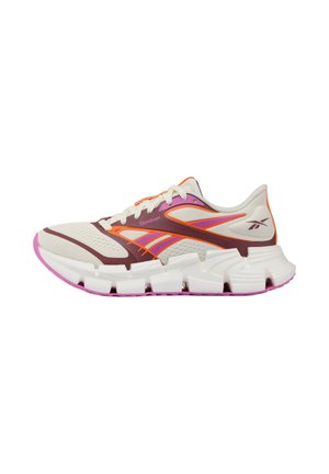 Lichtbeige, oranje en paarse sportsneaker met witte gesegmenteerde zool en ademend mesh bovenwerk, zichtbaar Reebok-logo aan de zijkant.