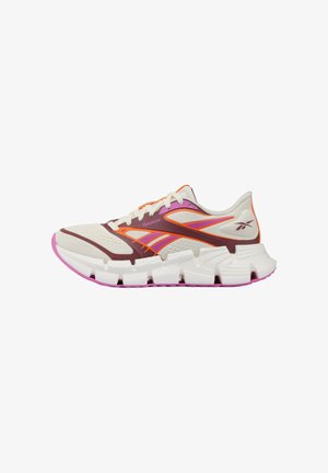 Lichtbeige, oranje en paarse sportsneaker met witte gesegmenteerde zool en ademend mesh bovenwerk, zichtbaar Reebok-logo aan de zijkant.