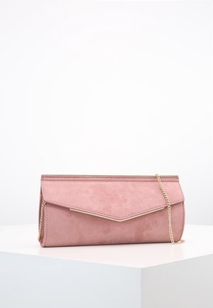 Roze suède enveloppeclutch met gouden afwerking en een delicate gouden kettingriem, liggend op een wit oppervlak tegen een effen achtergrond.