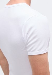 Wit T-shirt met korte mouwen, met een aansluitend ontwerp, katoenen materiaal, gladde textuur en een klassieke ronde halslijn.