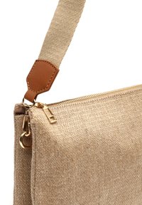 Beige stoffen crossbody tas met een gestructureerd oppervlak, leren schouderband en accenten, gouden ritshardware en een compacte rechthoekige vorm.