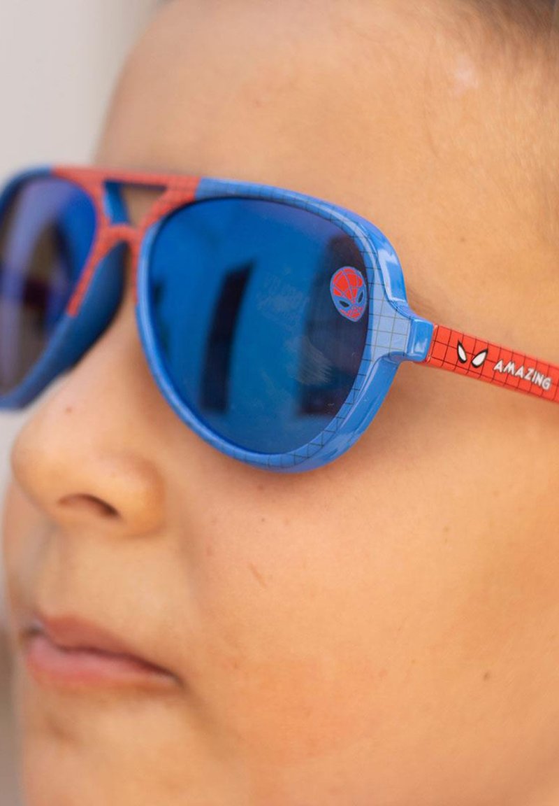 Blue and red Spider-Man sunglasses with oval lenses, textured frames, and character details on the arms. Reflective blue lenses.