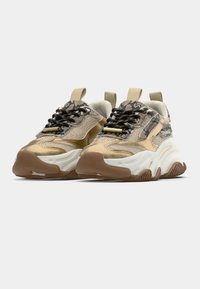 Sneakers met een mix van beige en bruine texturen, voorzien van een slangenhuidpatroon, zwarte veters en een dikke witte rubberen zool.