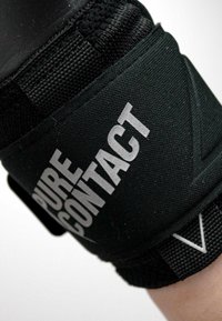 Zwarte elastische polsondersteuning met "PURE CONTACT" in het wit gedrukt. Het materiaal is gestructureerd met een beveiligingsband voor een verstelbare pasvorm.