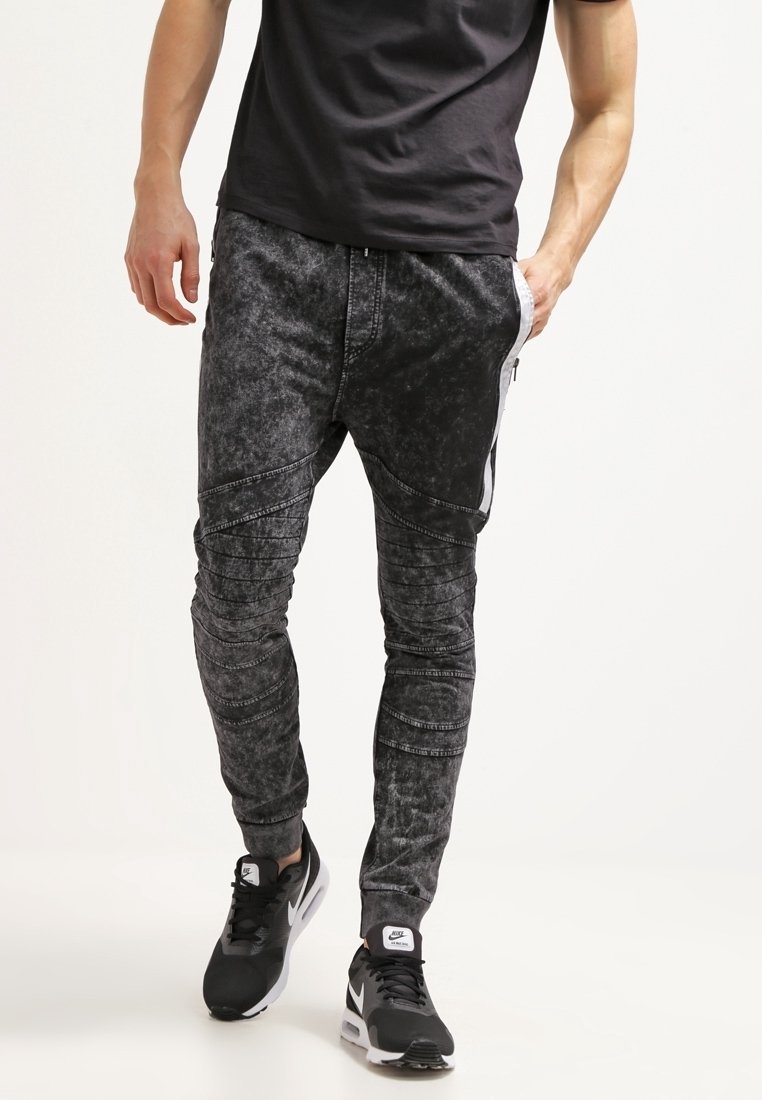 Černé jogger kalhoty s acid-wash efektom, těsným střihem, strukturální tkaninou, kontrastními bočními pruhy a akcentovanými švy.