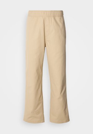 Beige vidde bukser med elastisk midje, laget av glatt bomullsstoff, med sidelommer og en rett silhuett.